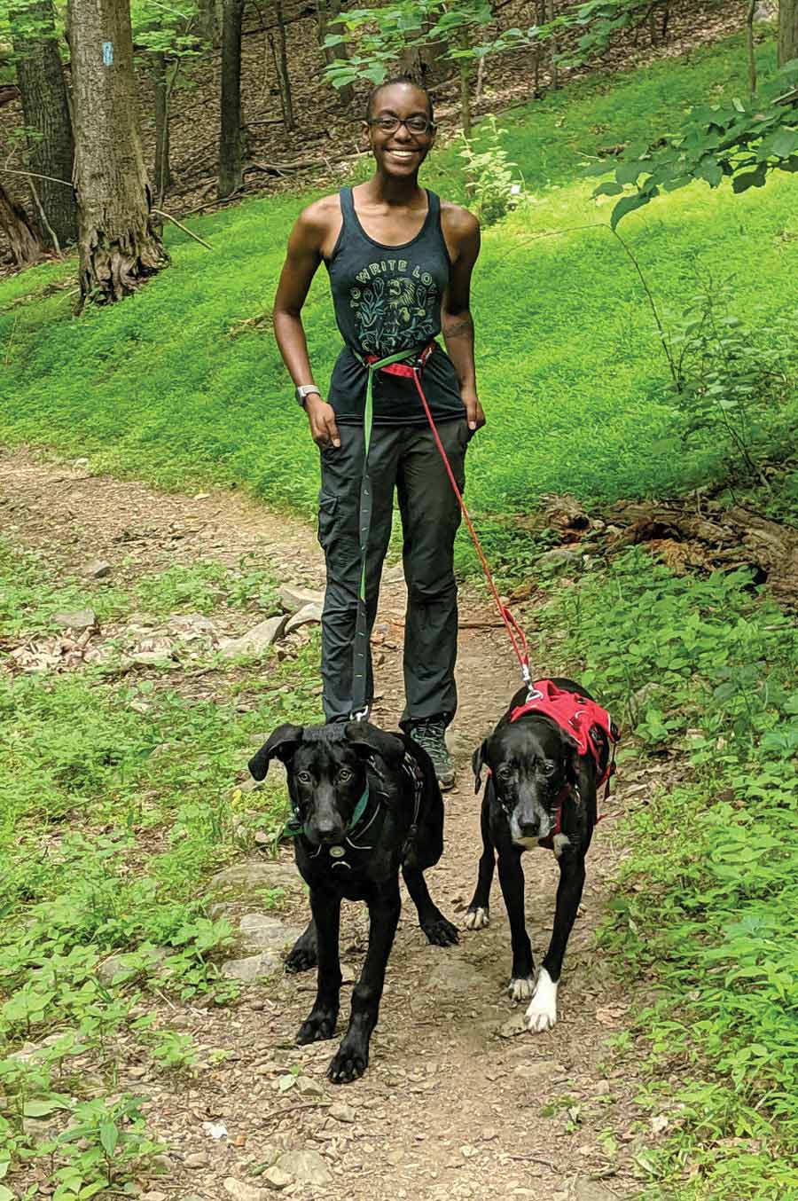woman hiking with her two dogs