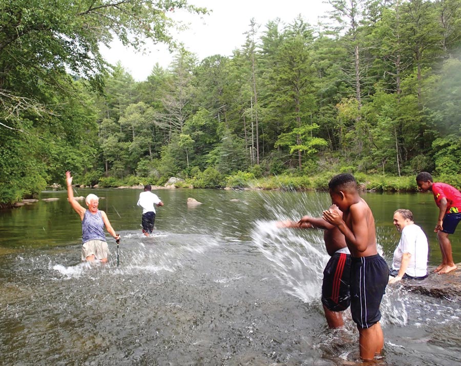 group of people playing and splashing in the river