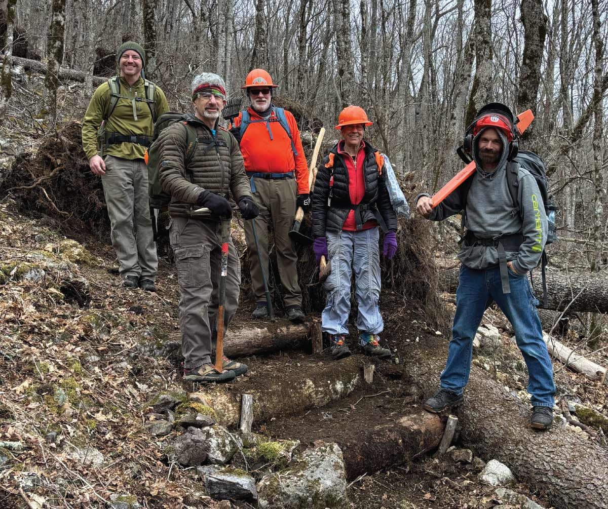 crew smiling for group photo while working in the woods
