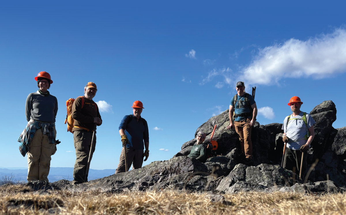 crew standing with tools on rocks