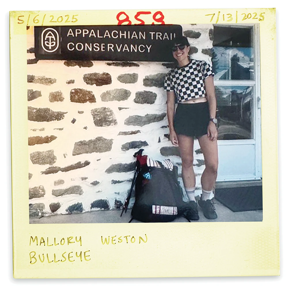 Appalachian Trail thru-hiker Mallory Weston posing with her backpack outside the Conservancy headquarters building.
